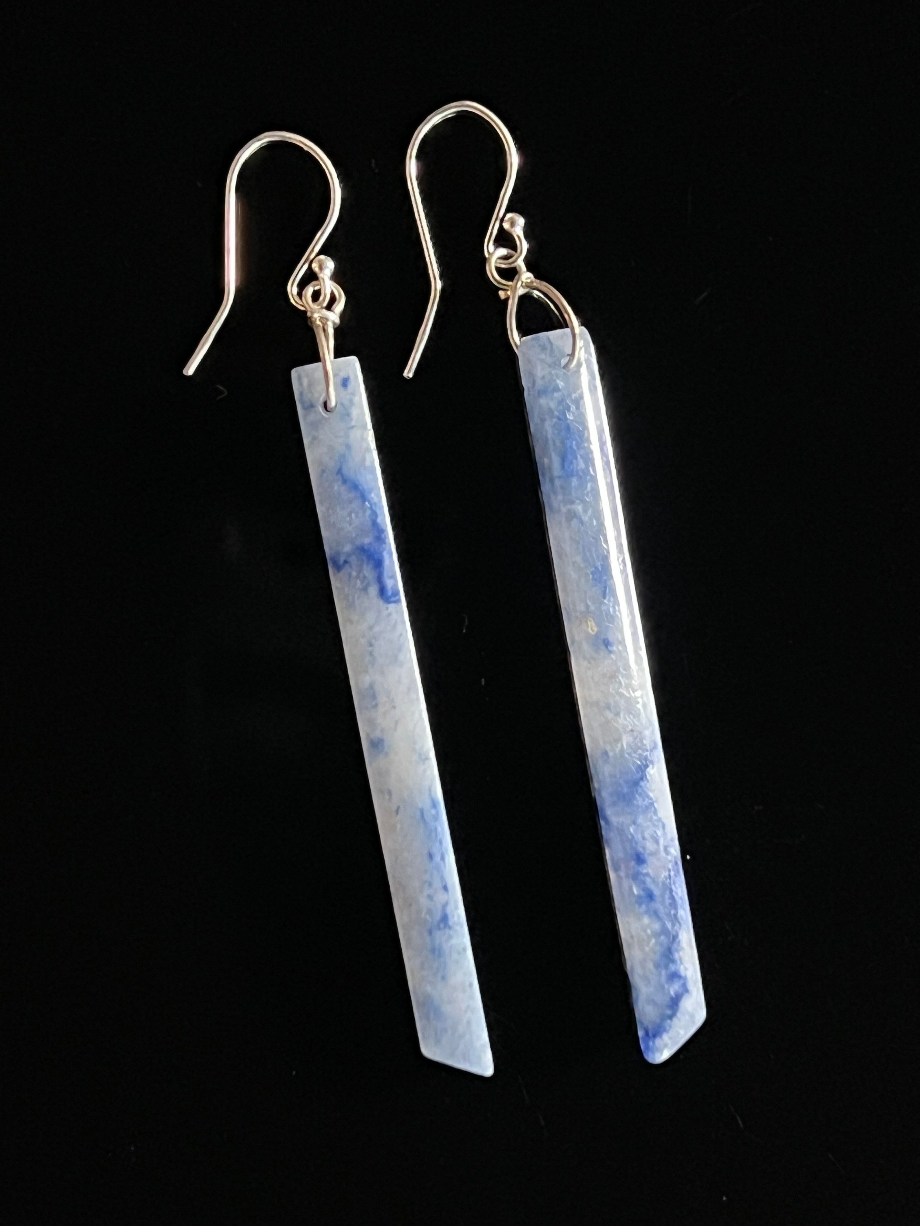 Pair of blue aventurine long bar drop earrings with sterling silver fish hook wires on a black background, showing cerulean and white stone veining