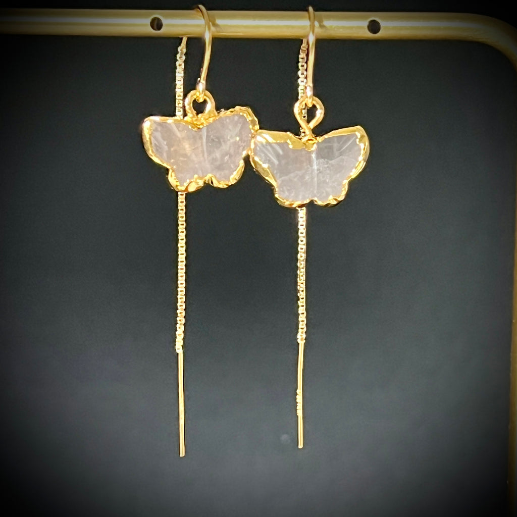 Pair of rose quartz butterfly threader earrings in 14K gold fill hanging on a gold bar, dark background, showing carved blush stone and long box chain drop by Studio MS Indie Jewelry