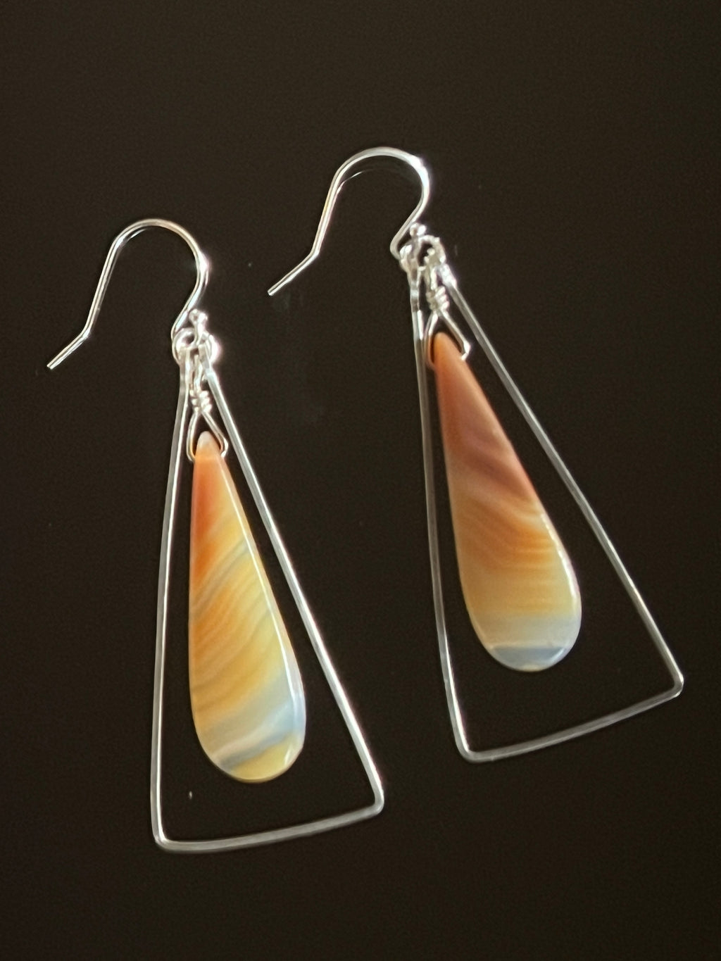 Hand formed sterling silver triangle earrings with sardonyx drop, caramel and coral banding